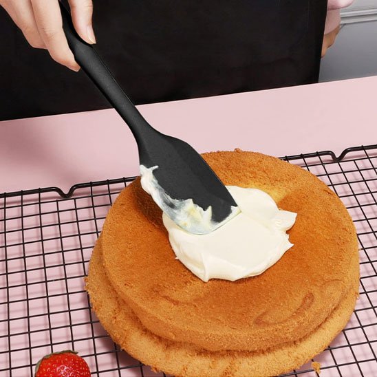 Nappage précis de crÚme chantilly avec une spatule noire
