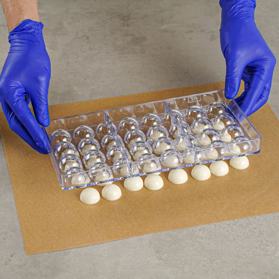 Remplissage de chocolat blanc dans un moule rigide en polycarbonate