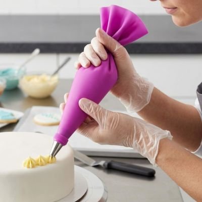 Prise en main d'une poche à douille pâtissière rose souple et lavable