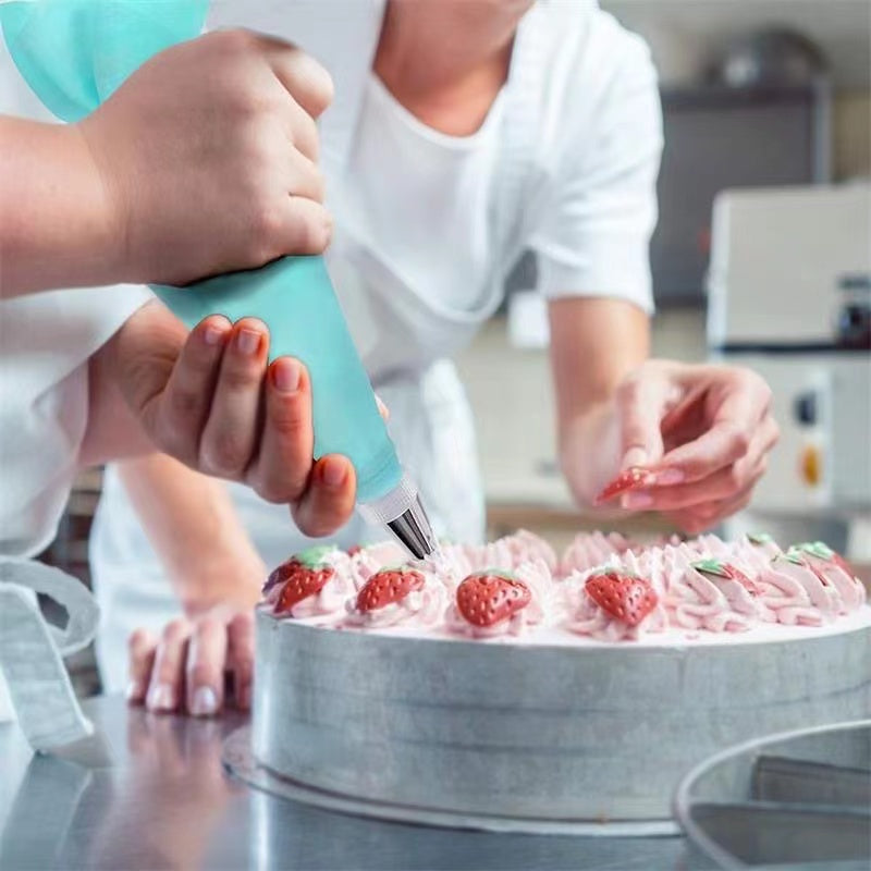 Pâtissier décorant un gâteau aux fraises avec une poche à douille