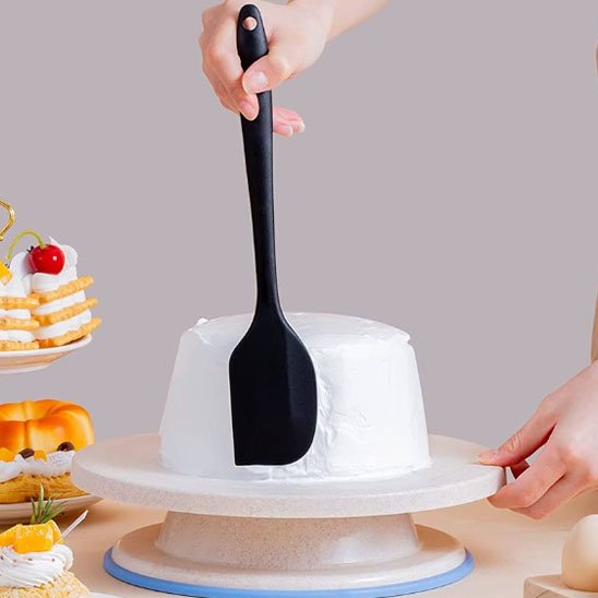 Spatule de pâtisserie étalant du glaçage sur une génoise